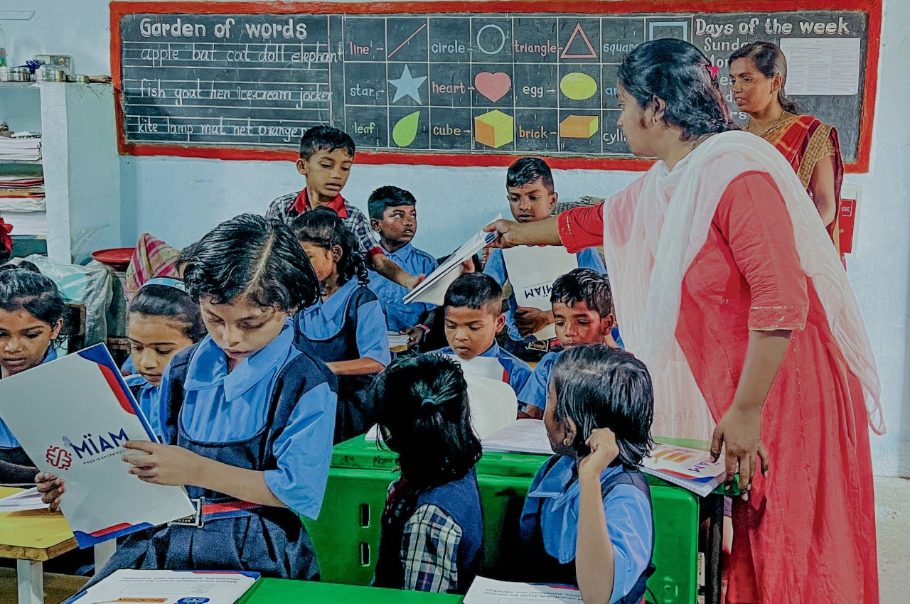 Nitu Joshi distributing books to children in a village school